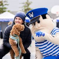 Louie poses for a photo with an alum and his dog